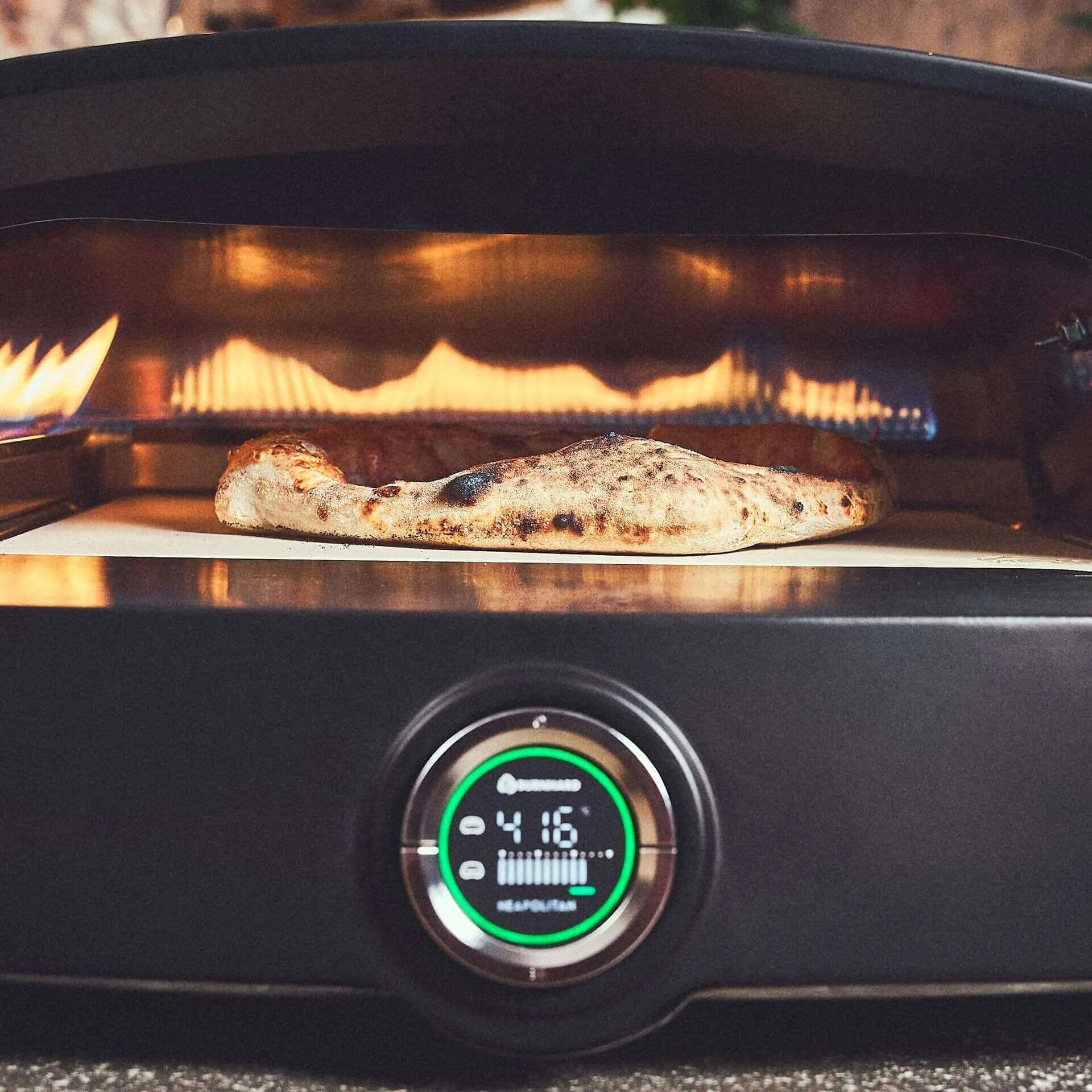 Fat TONY Pizzaofen zeigt auf Thermometer die Temperatur 416 °C an, während eine Pizza im Ofen backt