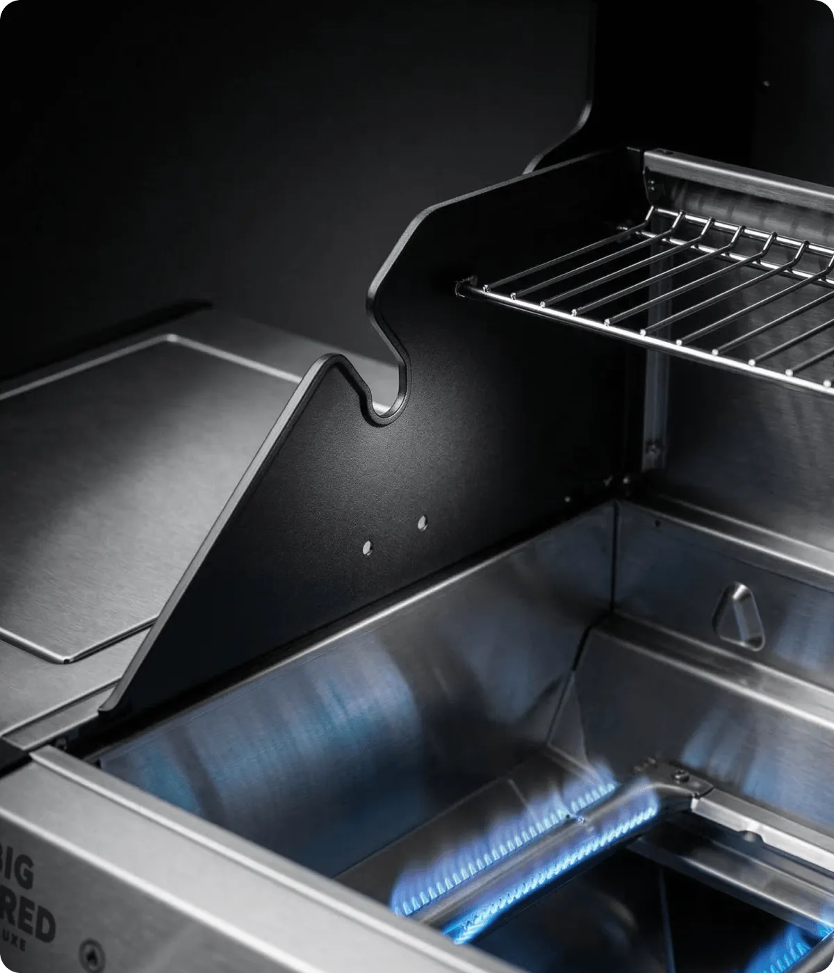 Alu-Druckguss Brennkammer Innenraum eines Gasgrills mit Warmhalterost und Edelstahlbrennern bei aktiver Flamme