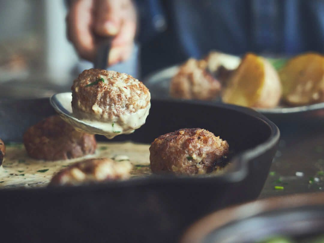 Köttbullar gebraden in een gietpan.