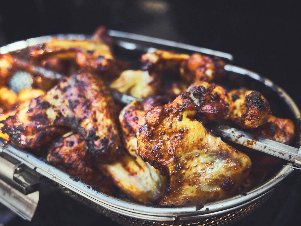 Kippenvleugels grillen in de draaispies-grillmand.