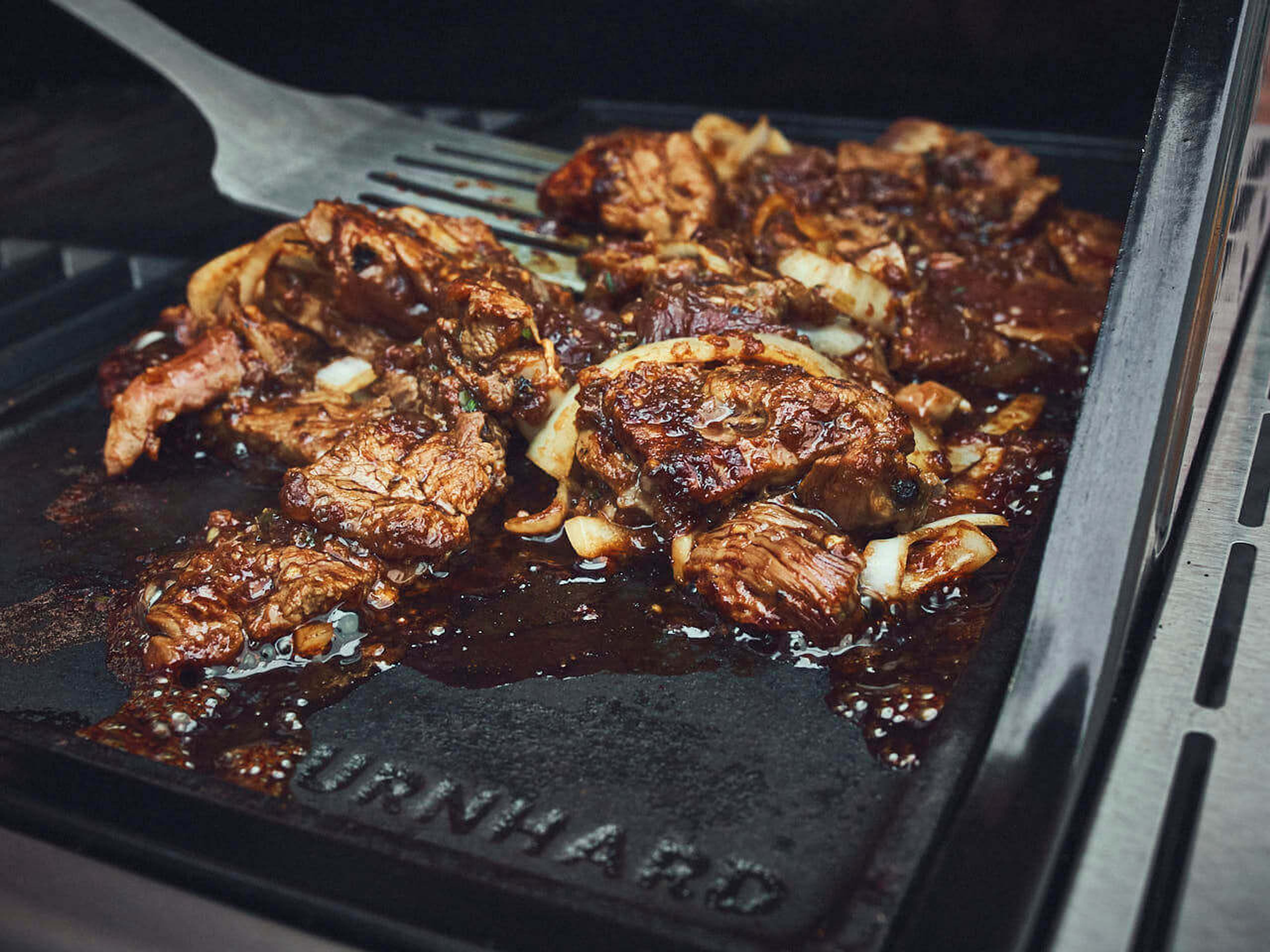 Koreanisches Bulgogi Fleisch wird auf der Gusseisenplatte gegrillt